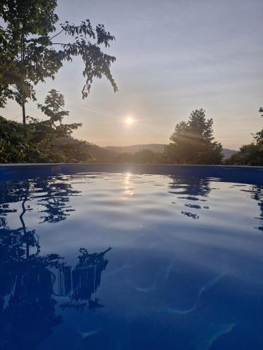 a pool of water with the sun setting in the background at Ecoresort Portobali in Jugueiros