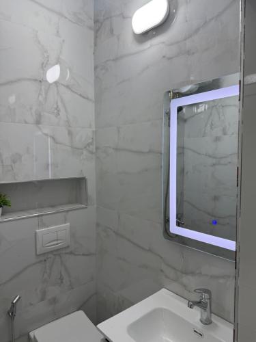 a white bathroom with a sink and a mirror at ELIO's Room in Durrës