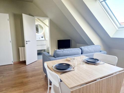 a living room with a table and a couch at L'Ermitage Scandi in Cherbourg en Cotentin