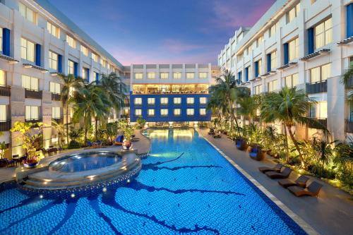 a large swimming pool in the middle of a building at Novotel Jakarta Mangga Dua Square in Jakarta