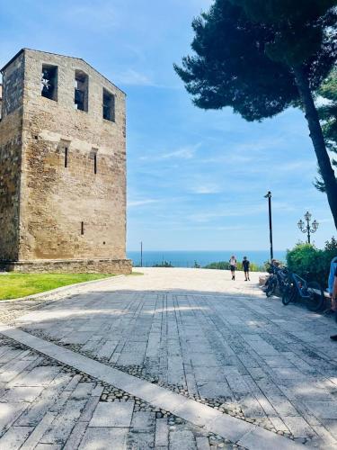 a stone building with a tree next to the ocean at La Presentosa b&b in Fossacesia