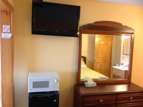 a hotel room with a microwave and a mirror at The Moulton Hotel in Hampton