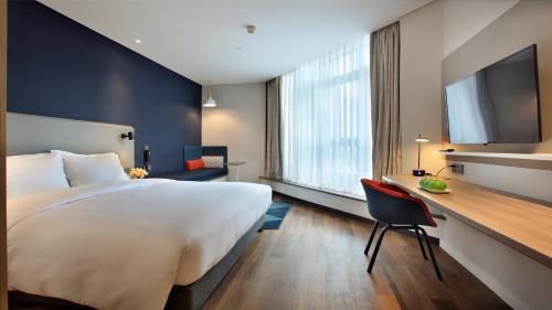 a hotel room with a large bed and a desk at Holiday Inn Express Guilin City Center by IHG in Guilin