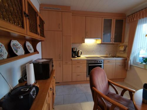 a kitchen with wooden cabinets and a table and chairs at Ferienhaus Mooi Huus 95157 in Rhauderfehn