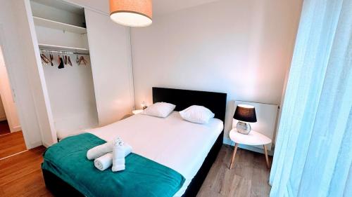 une chambre avec un lit avec des serviettes dessus dans l'établissement le quai douillet, à Bordeaux