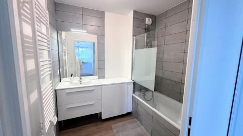 une salle de bain blanche avec un lavabo et une douche dans l'établissement le quai douillet, à Bordeaux