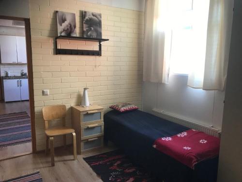 a small bedroom with a bed and a chair at Hillilän Koulu in Kalajoki