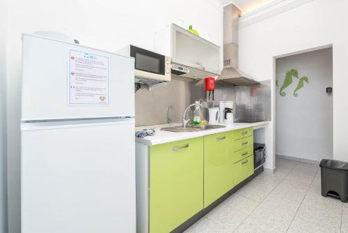a kitchen with green cabinets and a white refrigerator at Blife Riamya private apartment in Faro