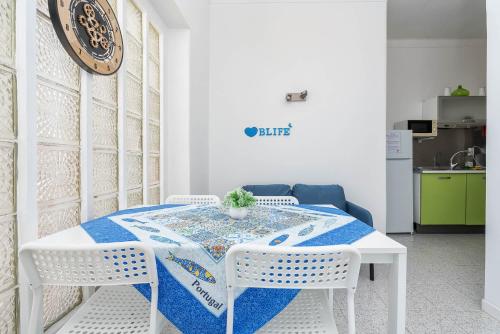 a white table with two white chairs and a blue table cloth at Blife Riamya private apartment in Faro