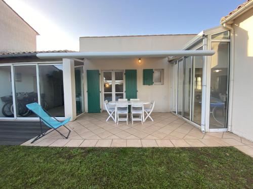un patio avec une table et des chaises dessus dans l'établissement La maison des Boutons d Or, à Sainte-Marie de Ré