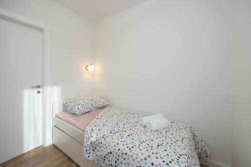 a small bedroom with a bed and a mirror at Apartment Happy Place in Kaštela