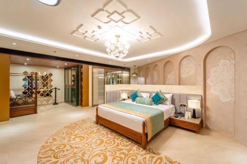 a bedroom with a large bed and a chandelier at Sayaji Indore in Indore