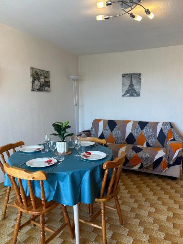d'une table à manger, de chaises et d'un canapé. dans l'établissement L'Escapade de Jules, au Cap d'Agde