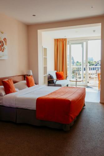 a hotel room with a large bed and a balcony at Hotel Victoria in Bergen aan Zee