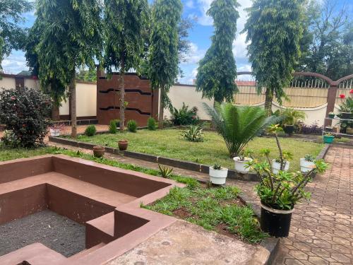 a garden with a raised bed with plants and trees at Kivuli Inn in Moshi