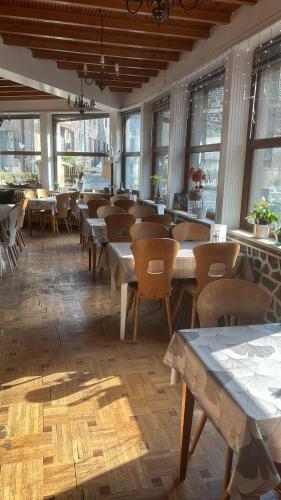 une salle à manger avec tables, chaises et fenêtres dans l'établissement L'Ajasserie d'Orcival, à Orcival