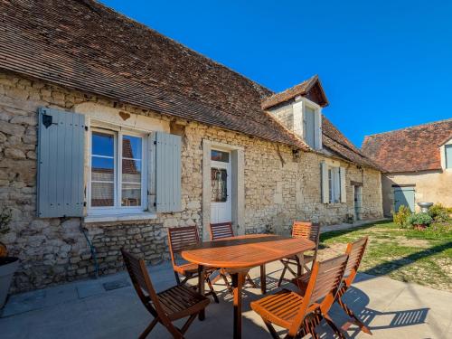 a patio with a wooden table and chairs at Gîte Chez Renée in Azay-le-Ferron