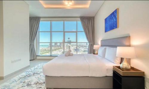 ドバイにあるStunning Sea View 2BR Luxury Apartment in Marinaの大きなベッドと大きな窓のある寝室