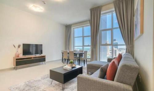 ドバイにあるStunning Sea View 2BR Luxury Apartment in Marinaのソファとテレビのあるリビングルーム