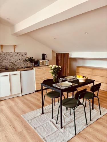 une cuisine et une salle à manger avec une table et des chaises noires dans l'établissement Charming studio, bright, central, quiet, à Saint-Étienne