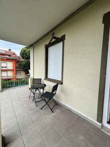 a patio with two chairs and a table and a window at Zia Pina Apartment in Caselle Torinese