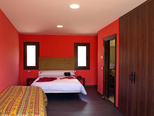 a bedroom with red walls and a bed in it at Casa Arrieta in Castejón de Valdejasa