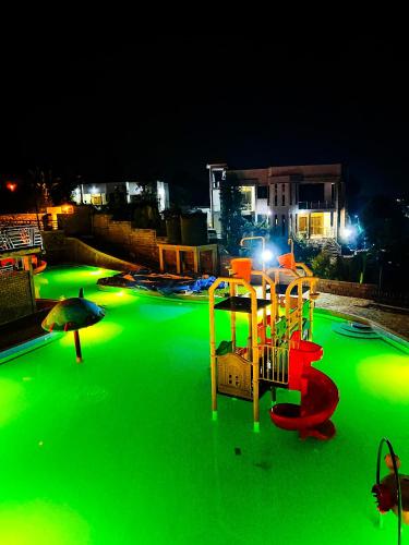 a playground with green lights in a park at night at Masaka Cultural Resort in Masaka