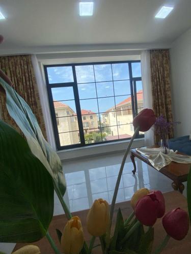 a room with a window and a table and flowers at Style Home Buzovna in Baku