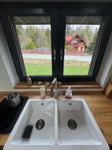 a white sink in a kitchen with two windows at Ostoja Zawoja in Zawoja