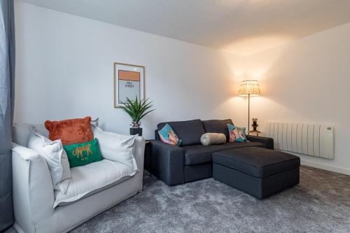 a living room with a couch and a chair at Countryside Stay Near JCB, Peaks & Alton Towers in Rocester