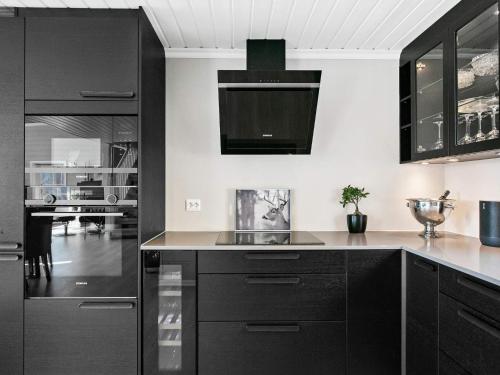 a black and white kitchen with black cabinets at 8 person holiday home in Valldal in Valldal