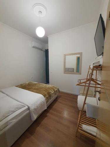 a bedroom with a bed and a television in it at Kutal Park Inn Hotel in Përmet
