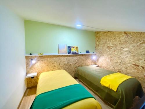 a bedroom with two beds and a stone wall at Villa Rio in Praia do Ribatejo