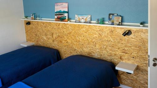 a room with two blue beds and a wall at Villa Rio in Praia do Ribatejo