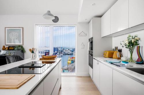 een witte keuken met uitzicht op een haven bij Dolce Vita - Duplex Apartment with Incredible Harbour Views in Poole