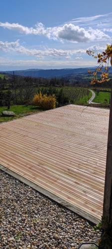 une grande terrasse en bois avec vue sur une route dans l'établissement Studio les femmes, à Bosas