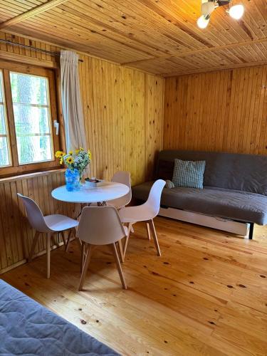 a room with a table and chairs and a couch at Perła in Stegna