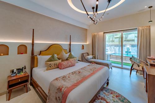 a bedroom with a bed and a desk and a window at Sayaji Indore in Indore