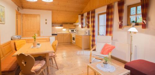 a small living room with a table and a kitchen at Bergbauernhof Untermoos in Taxenbach