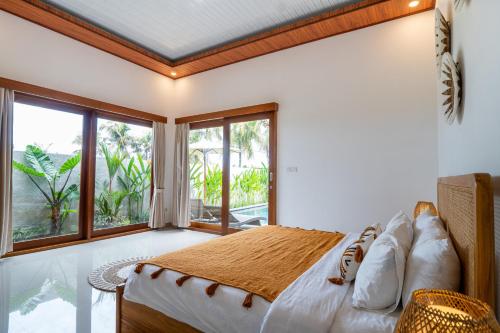 a bedroom with a bed and a large window at Obah Villa Ubud 1 Br Brand new private villa in Ubud