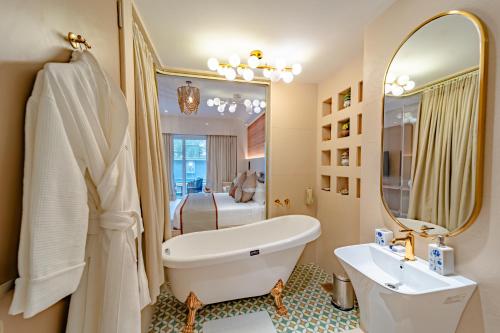 a bathroom with a tub and a sink and a mirror at Sayaji Indore in Indore