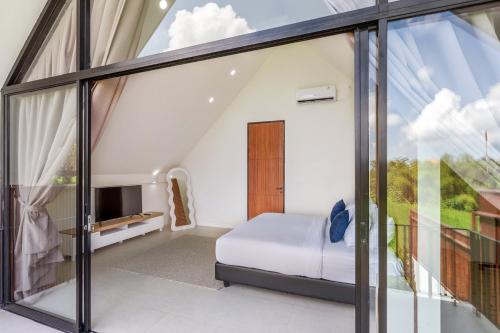 a bedroom with glass doors and a bed and a tv at Nova - Six Stars Townhouse 2BR with Private Pool in Canggu in Dalung