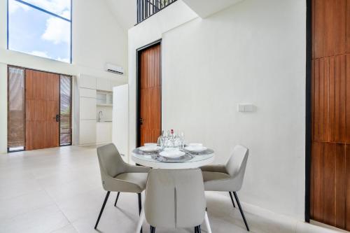 a dining room with a white table and chairs at Nova - Six Stars Townhouse 2BR with Private Pool in Canggu in Dalung