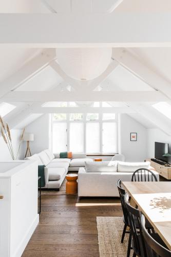 a living room with white furniture and a table at The Millbrook Inn in Kingsbridge
