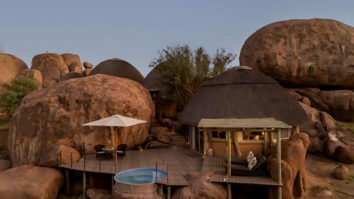 a group of dome shaped homes with an umbrella at Mowani Mountain Camp in Khorixas