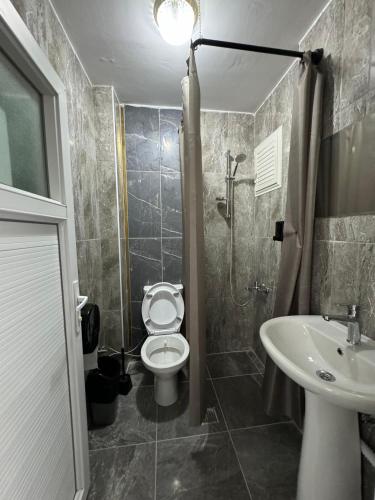 a bathroom with a toilet and a sink at ANA GÜNEY Apart Otel in Nilüfer