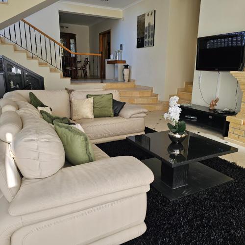 a living room with a white couch and a table at Jose & Idalina House in Funchal