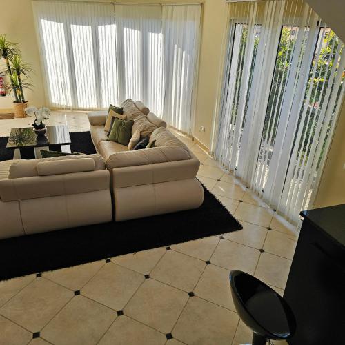 a white couch in a living room with large windows at Jose & Idalina House in Funchal
