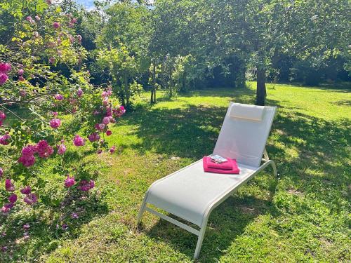 a white chair with a red phone sitting on it at Patio des Rêves - Charme au cœur du Gers in Aujan-Mournède