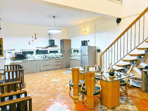 a kitchen with a staircase and a table and chairs at Orchid Nirvana 3Bhk Villa in Dod Jāla